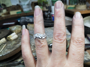 A hand showing off the sterling silver Celtic spirals band, an Irish wedding ring