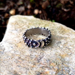 Detail of blackened sterling silver Bubble Ring with a buckle effect pattern and little bubble decorations. Designed and handmade in Ireland.