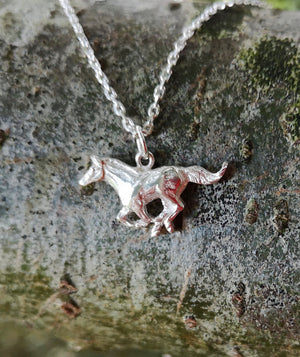 Sterling silver Mustang Horse Pendant hanging from tree branch. Handmade in Ireland by Elena Brennan.