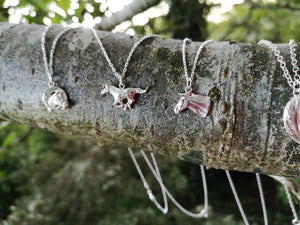 Irish Horse pendant collection hanging on tree branch. Handmade by Elena Brennan in Cavan, Ireland.