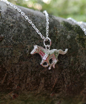 Sterling silver Mustang Horse Pendant hanging from tree branch. Handmade in Ireland by Elena Brennan.