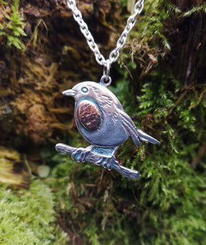 Robin Red Breast Pendant, An Spideog, hanging against mossy tree bark.
