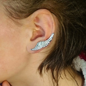 A woman showing off an ear wearing a sterling silver handmade Angel Wings Ear Cuff earring. This angel jewelry piece is part of the Irish My Angel jewelry collection