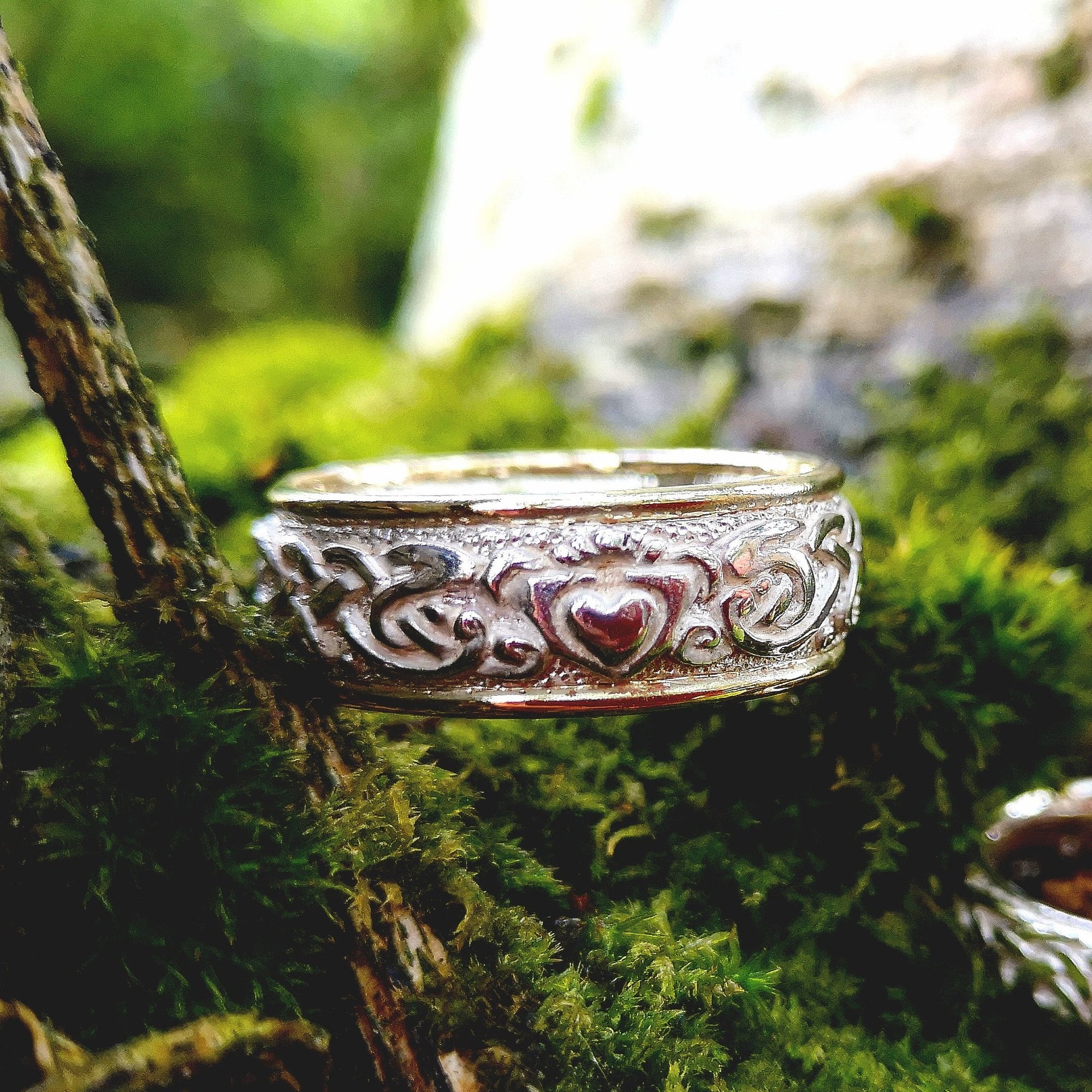 Celtic Claddagh wedding band handmade by Elena Brennan Jewellery with 9ct yellow 1.3mm bands either side. This Celtic jewelry piece is perched on green moss.