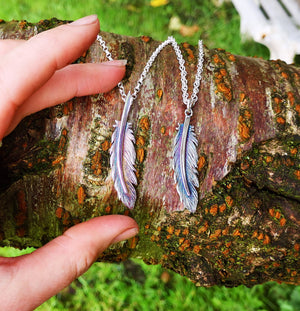 The Earth Angel Feather Pendant is handmade from Sterling Silver by Irish Jewellery Designer Elena Brennan, photographed on a log to show its size