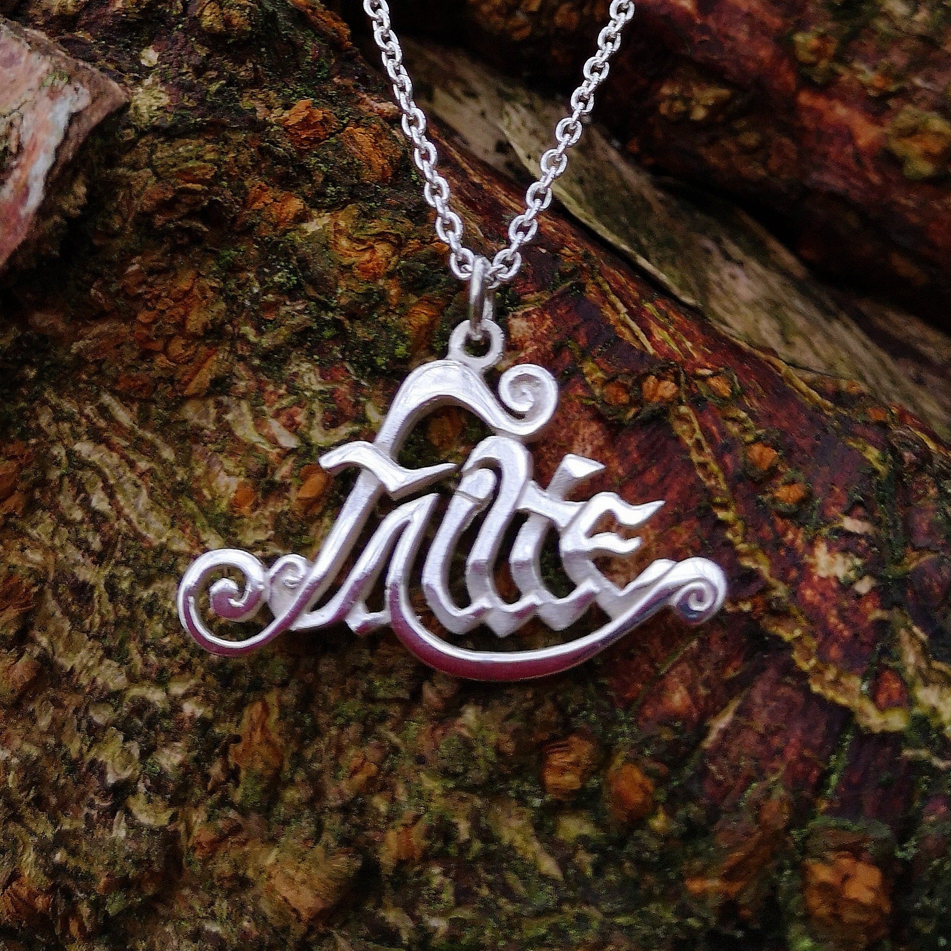 The sterling silver Fáilte Pendant hand made by Irish Jewellery Designer Elena Brennan. This Gaelic welcome pendant is hanging from a tree