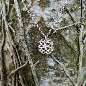 The sterling silver Celtic Knot Pendant, made in Ireland. This celtic knot jewelry piece is hanging beautifully from a tree at Irish Jewellery Designer Elena Brennan's studio.