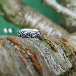 A closer look at the Irish handmade Claddagh wedding band handmade from Sterling Silver by Elena Brennan Jewellery. The Claddagh ring is perched on a tree branch