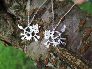 Daisy the Cow Pendant hanging on an 18 inch chain, handmade from sterling silver and complete with a 14ct gold flower.