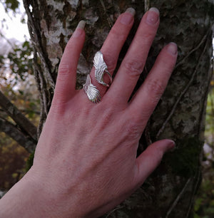 A hand wearing the sterling silver wraparound Curvy Angel wing ring. Made in Ireland by Elena Brennan Jewellery, part of the My Angel jewelry collection