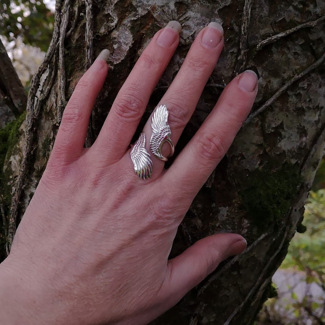 A hand wearing the sterling silver wraparound Curvy Angel wing ring. Made in Ireland by Elena Brennan Jewellery, part of the My Angel jewelry collection