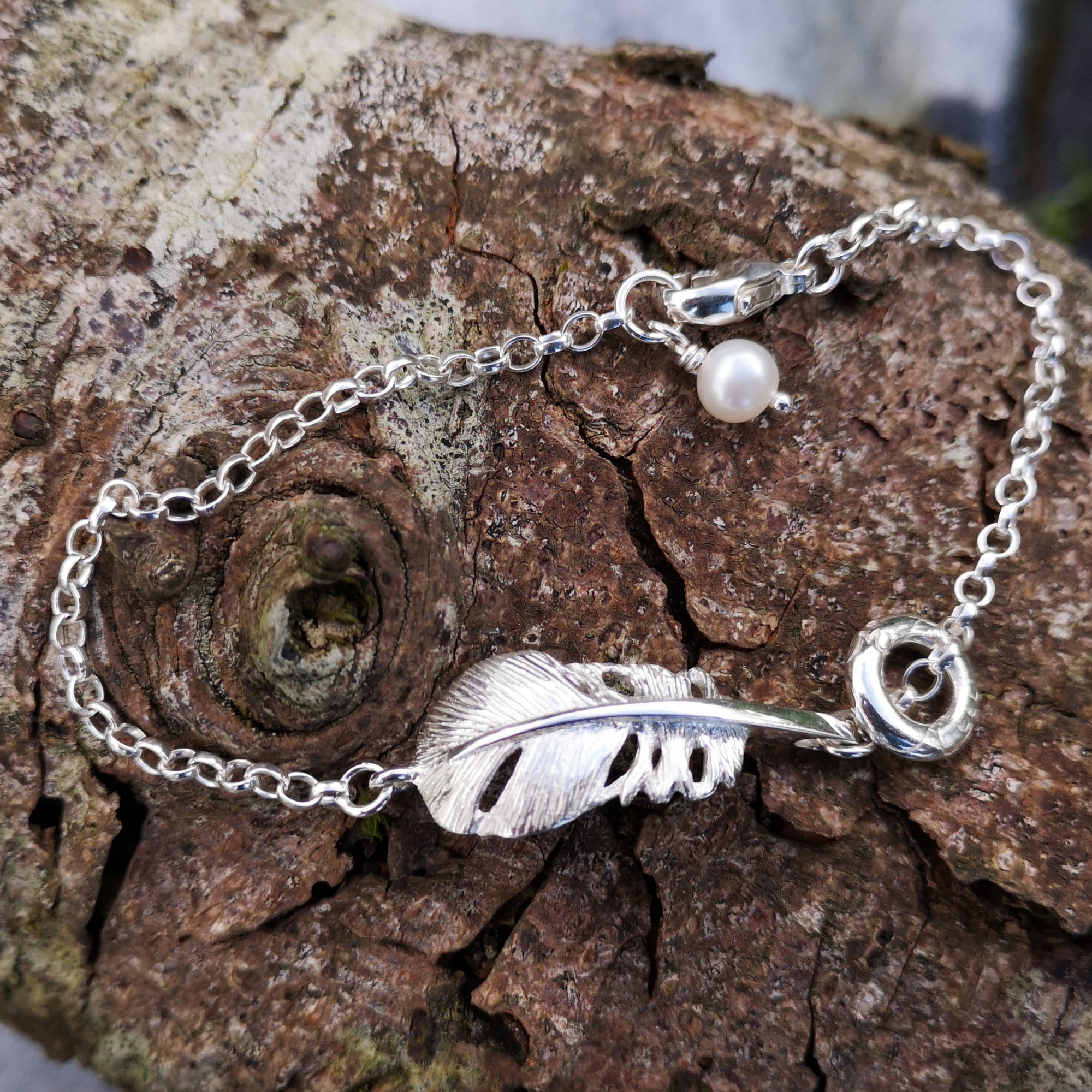 The "Cherish" Baby Angel Feather Bracelet from Elena Brennan's 'My Angel' collection, is made from Irish Sterling Silver. Here it is photographed against tree bark