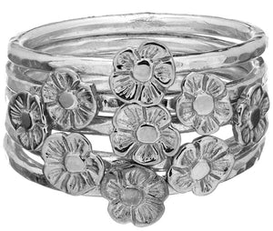 Tiny Flower Stacking Rings worn together forming a beautiful silver bunch.