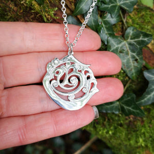 Hand showing off the An Cabhán pendant made of sterling silver, inspired by the beautiful Co. Cavan.