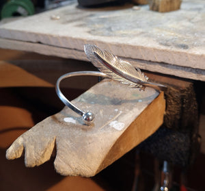 The handcrafted sterling silver Angel Feather Bangle displayed on Irish Jewellery Designer Elena Brennan's Studio. Part of the My Angel jewellery collection.