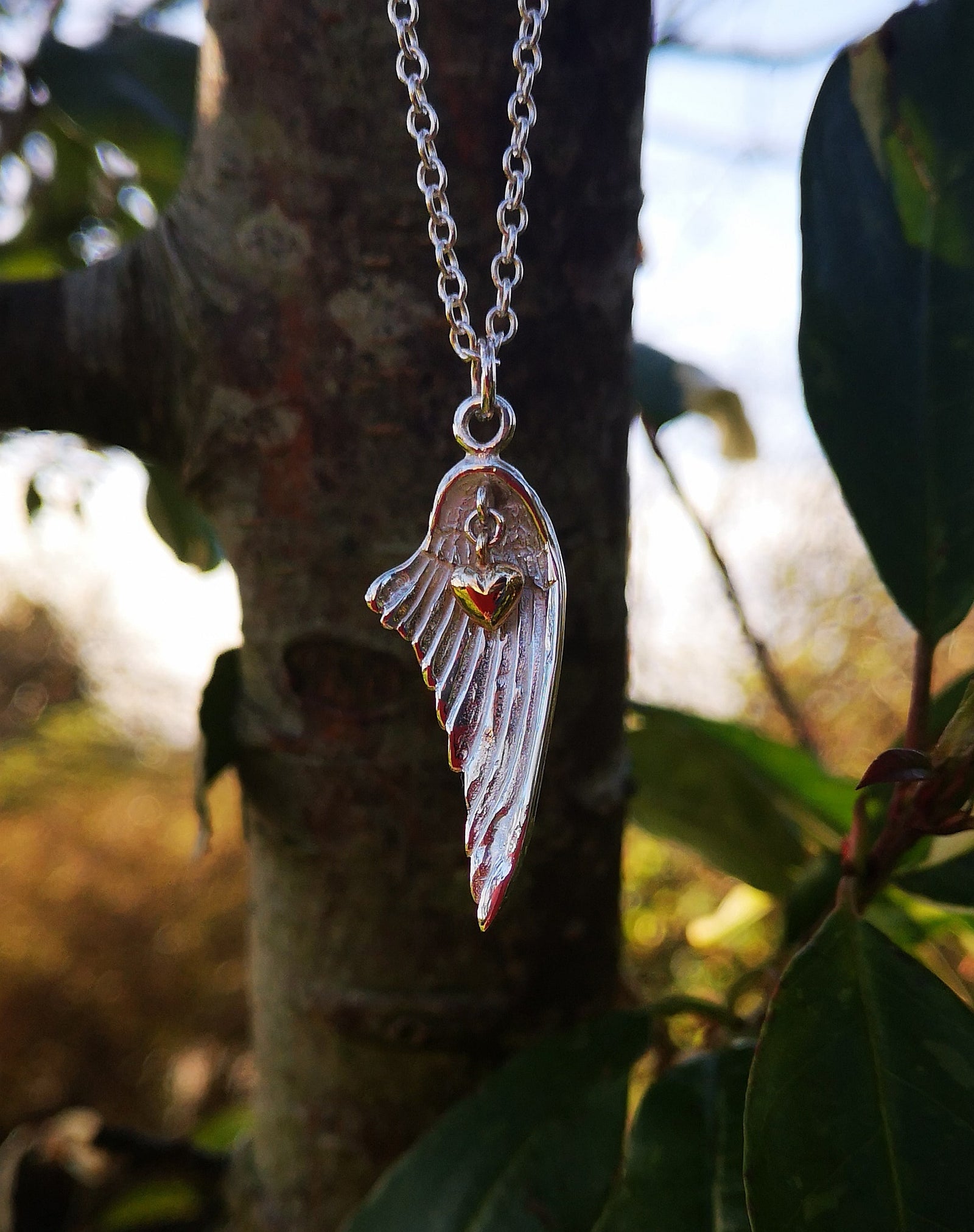 Angel wing necklace with gold heart decoration, handmade in Cavan, Ireland.