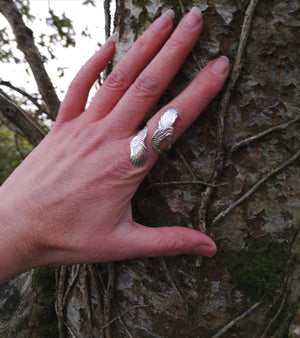 A hand wearing the sterling silver wraparound Curvy Angel wing ring. Made in Ireland by Elena Brennan Jewellery, part of the My Angel jewellery collection.