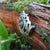 Detail of the Cavan (An Cabhán) Brooch made of sterling silver, sitting on tree bark. Its Celtic designs is inspired by the landscape of County Cavan.