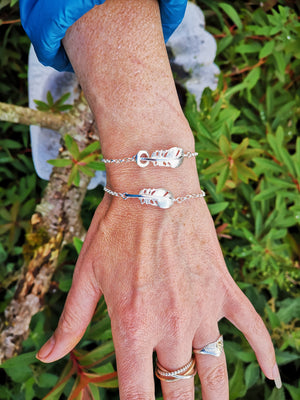 A woman wearing the "Cherish" Baby Angel Feather Bracelet from Elena Brennan's My Angel jewellery collection, is made from Irish Sterling Silver.