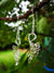 Swan Drop Earrings made from Sterling Silver, hanging from a tree branch. Inspired by the Irish legend, the Children of Lir, and handmade in Ireland.
