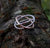 The Cúrsa an tSaoil Circles of Life tactile ring sitting on mossy tree bark. Handmade in Ireland.