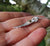 Close up of the angel wing and halo pendant made of sterling silver. This angel jewellery piece is handmade in Ireland.