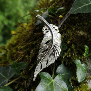 Silver angel feather brooch sitting on mossy tree bark. Part of the My angel jewellery collection, made in Cavan.