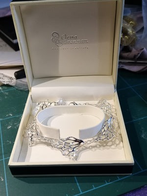 A sterling silver gossamer wave bracelet sitting in a jewellery box.