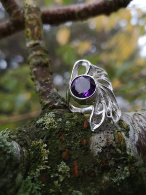 Sterling silver bespoke amethyst gossamer ring sitting on a tree branch.