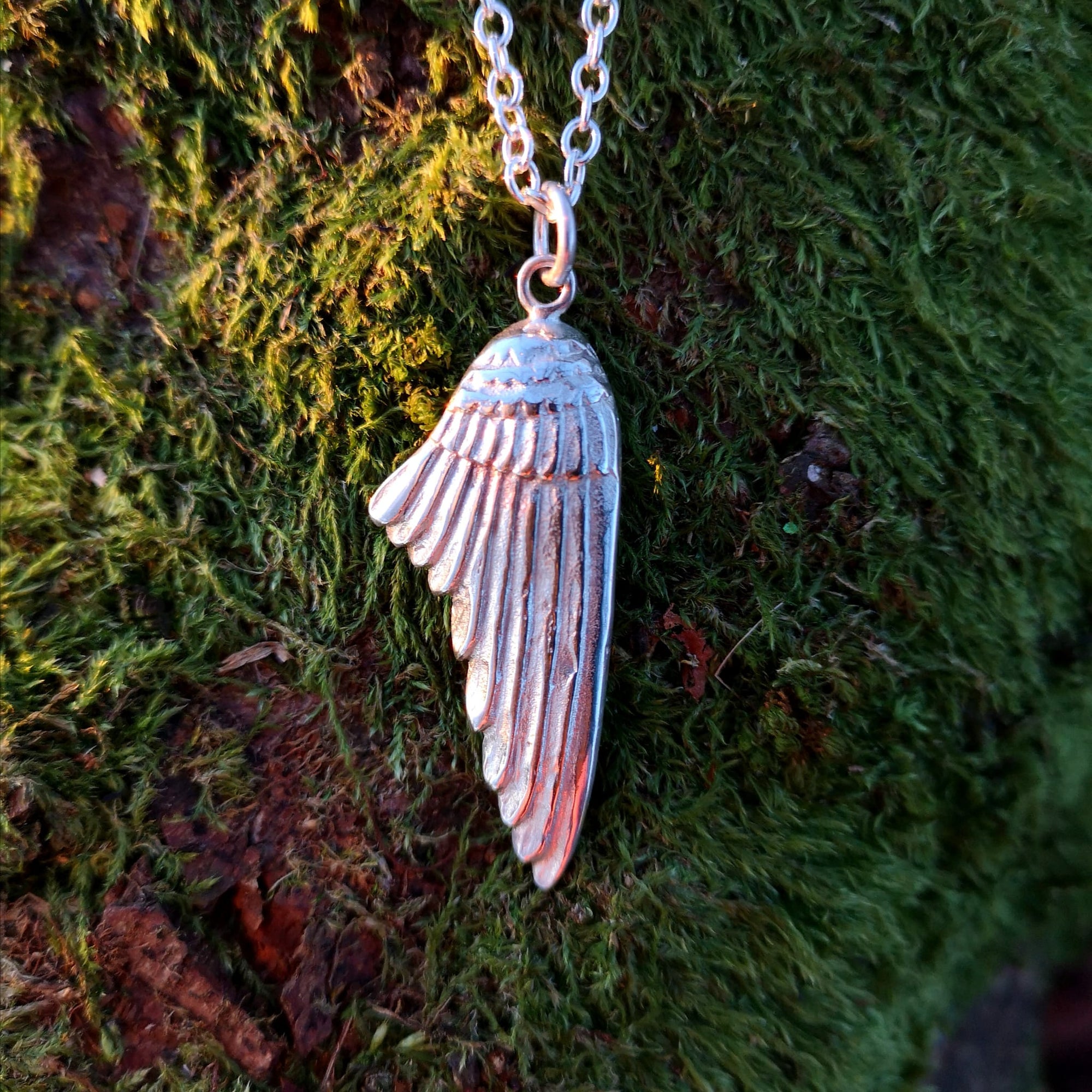 Right-folded angel wing pendant made of sterling silver.