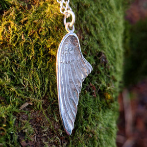 Detail of right-folded angel wing pendant made of sterling silver.