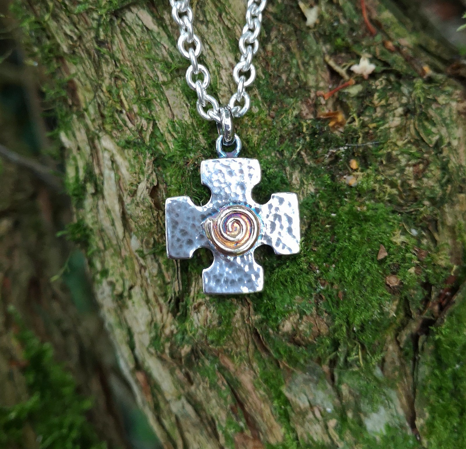 The Crux Quadrata, a Greek cross pendant with a gold spiral at the centre,  handmade in Cavan, Ireland, by Irish jewellery designer Elena Brennan