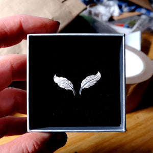 Small angel feather stud earrings made of sterling silver.