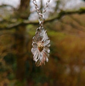 Side view of the dog daisy pendant. Made of sterling silver and gold, this daisy jewellery piece is handmade in Ireland.