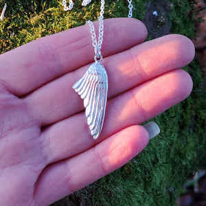 Right-folded angel wing pendant made of sterling silver.