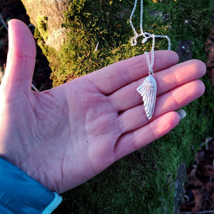 Right-folded angel wing pendant made of sterling silver.