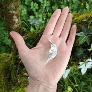 Hand showing off size of angel feather brooch. Part of the My Angel jewellery collection.