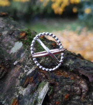 The Cúrsa an tSaoil Circles of Life tactile ring sitting on mossy tree bark. Handmade in Ireland.