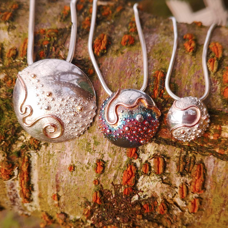 Small, medium and large bespoke Cúrsa an tSaoil pendants representing the circle of life, handmade by Irish jewellery designer Elena Brennan