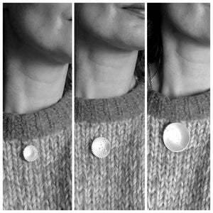 A woman showing off the Journey of Life silver pendant, an Irish jewellery piece made in Cavan, Ireland.