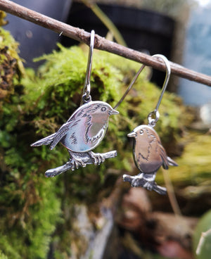 Robin Red Breast Communion earrings hanging on a twig. These sterling silver First Holy communion earrings are made by Elena Brennan Jewellery.