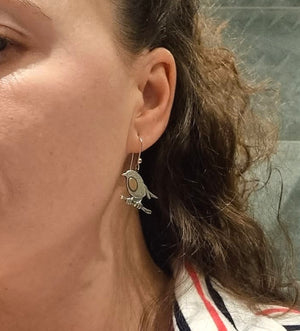 A woman wearing Robin Red Breast Communion earrings
