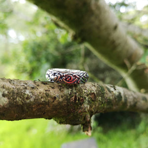 The handmade Celtic Claddagh Celtic Wedding Band is an Irish wedding ring and is perched on the branch of a tree outside Irish Jewellery Designers Elena Brennan's studio. 