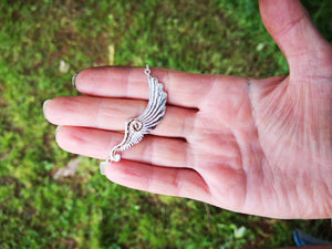 Silver angel wing necklace with gold spiral.